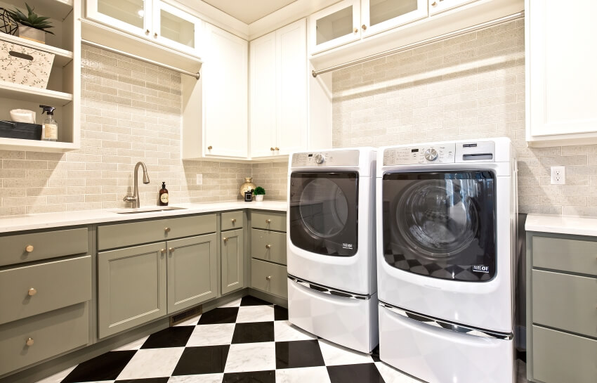 Checkered tile floor in laundry room with cream colored stone tile backsplash
