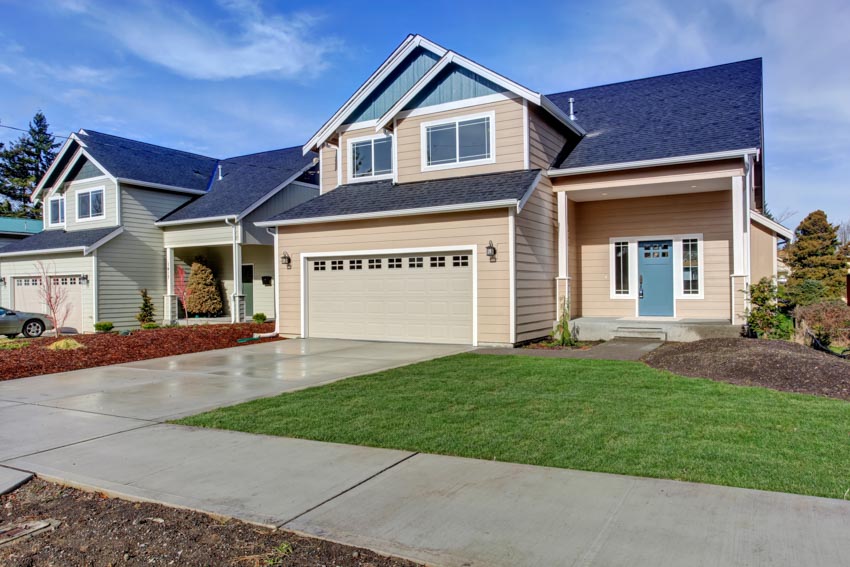 Classic house with finished driveway, garage, siding, sloped roof, dormer, and windows