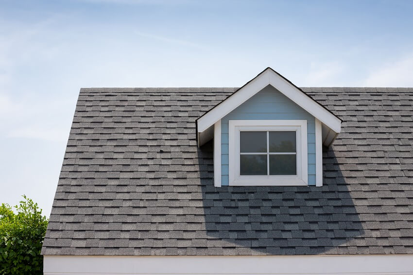 Clean shingle roofing with small attic window