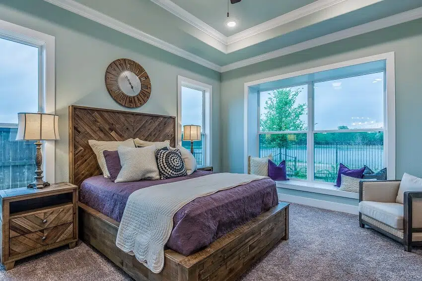 A gorgeous coastal themed bedroom with wooden furniture and a beautiful ocean view