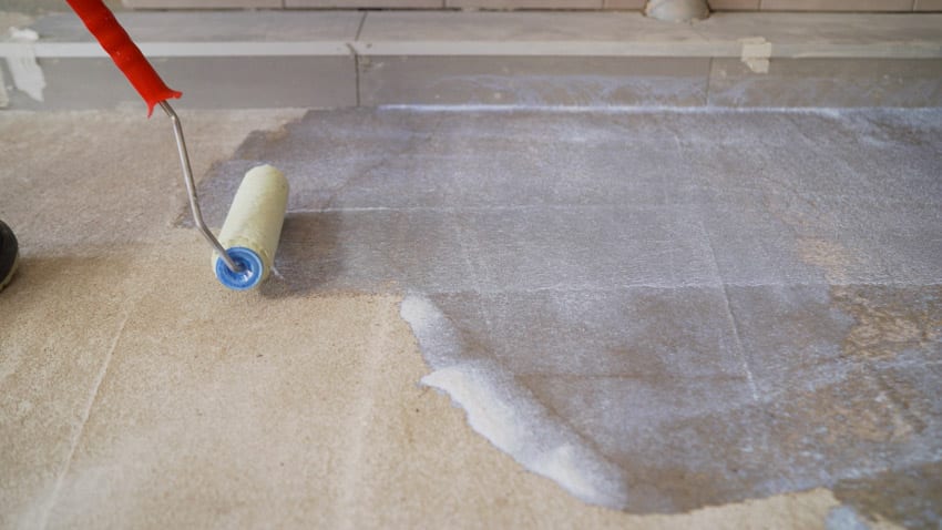 Contractor sealing concrete driveway floors