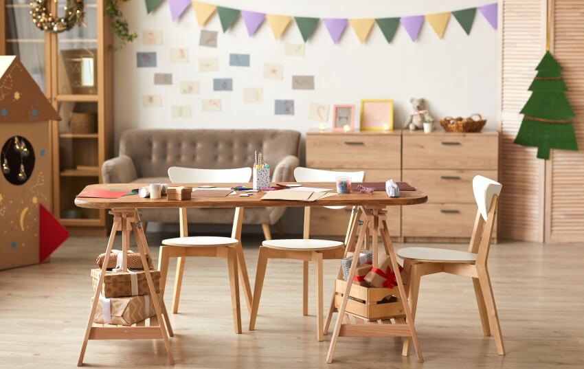 Cute kids craft room with wooden chairs and table, a couch and console table on the background