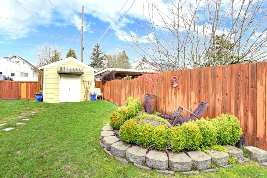 Cypress wood fenced backyard with shed and landscape design