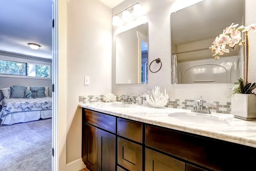 Bathroom with glass tile backsplash, dual mirror and orchid on a pot