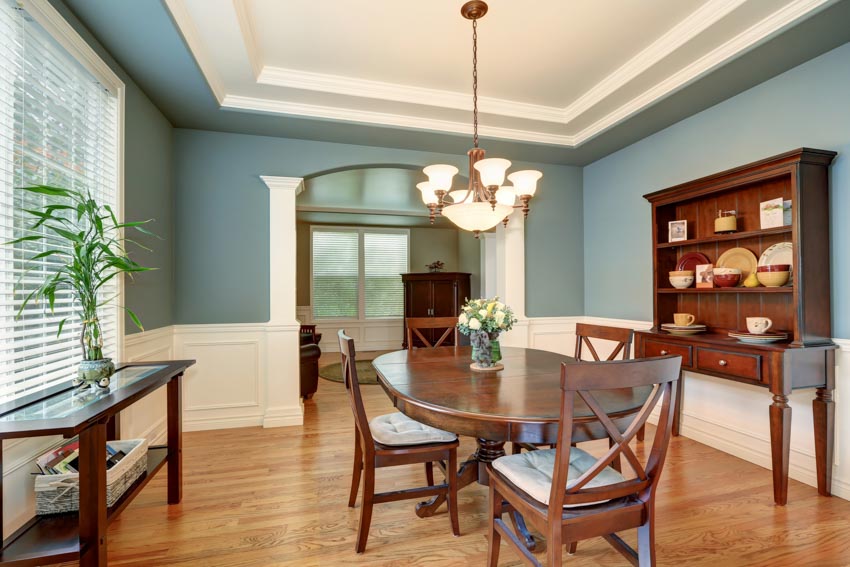 Room with teal walls, wainscoting, and teak wood furniture pieces