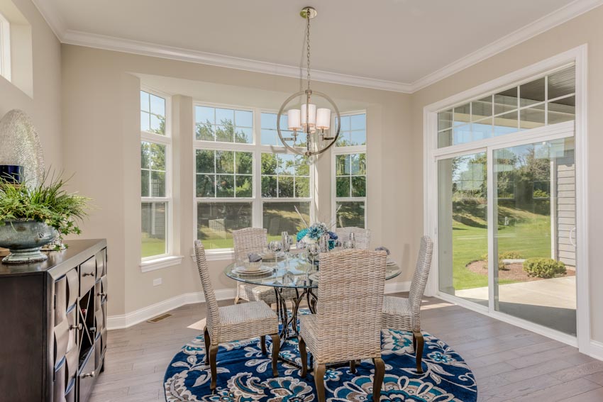 Dining room with white walls, pendant lights and glass window and doors