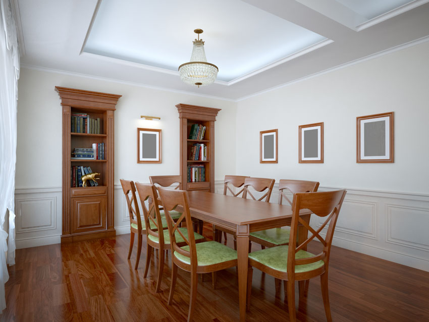 Dining space with table, chairs, wainscoting, and bookshelves