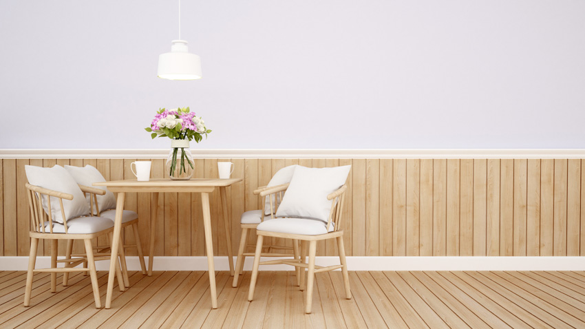 Dining space with wood plank wainscoting, table, and chairs