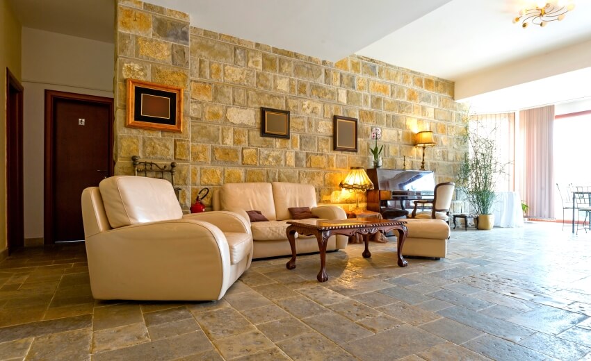 Elegant hotel lobby with French limestone floor and wall, piano, and leather seating
