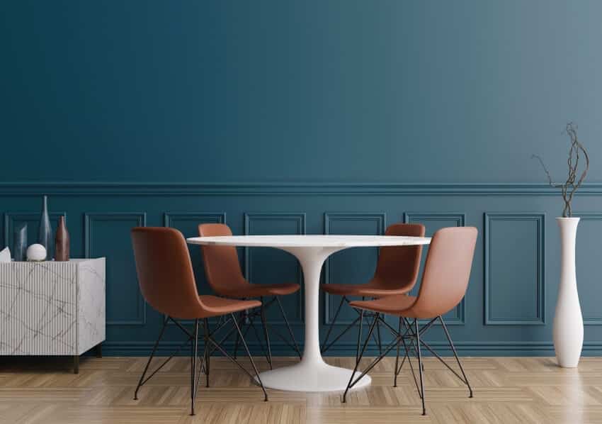 Empty blue wall in modern dining room with parquet floor, dining table with brown chairs
