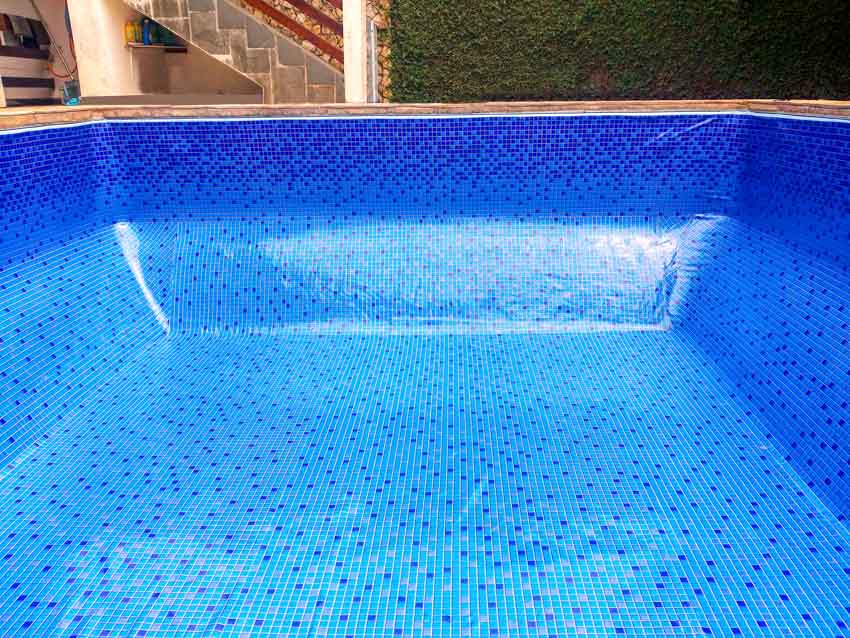 Empty swimming pool with mosaic tile design liner