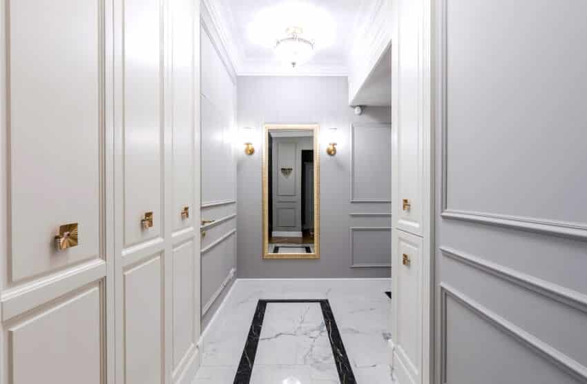 Entrance hallway in a modern apartment with grey walls, built-in wardrobe, and marble tile floor