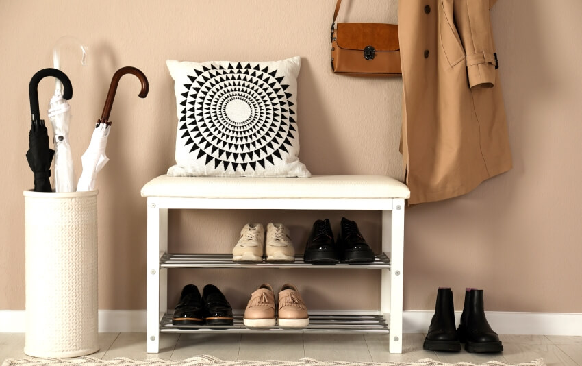 Entry hall with beige wall, shoe bench, and umbrella basket
