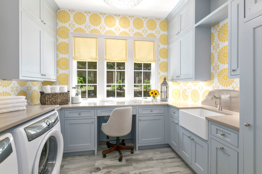 Farmhouse sink and desk in utility room with yellow patterned wallpaper