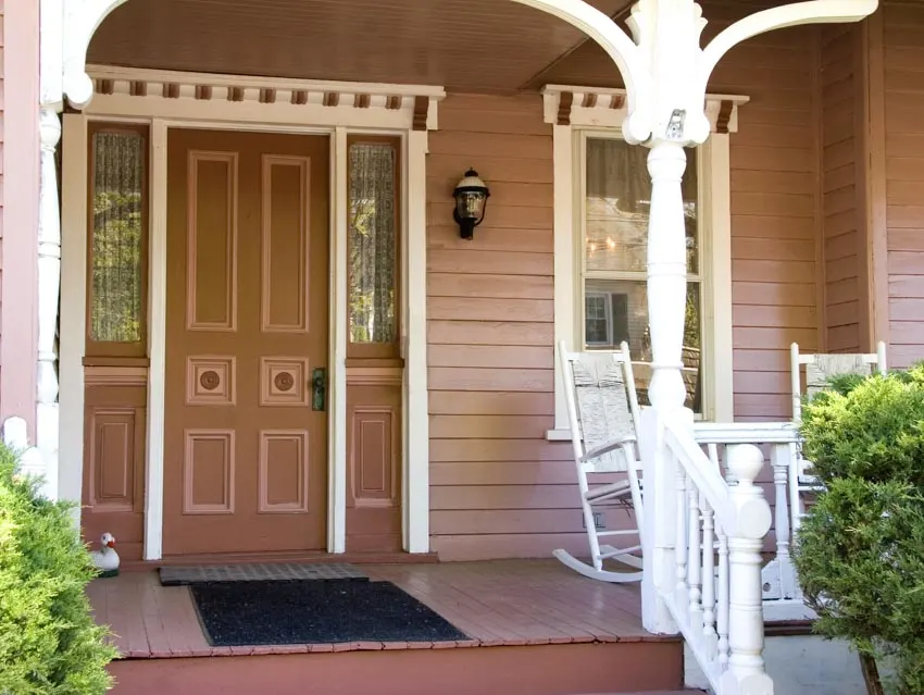 Front porch with siding wall, door, rocking chairs, and outdoor rug