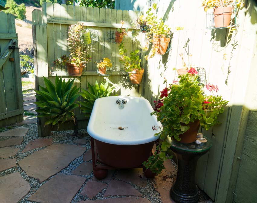 Garden with bathtub, paved walkway, and flowers