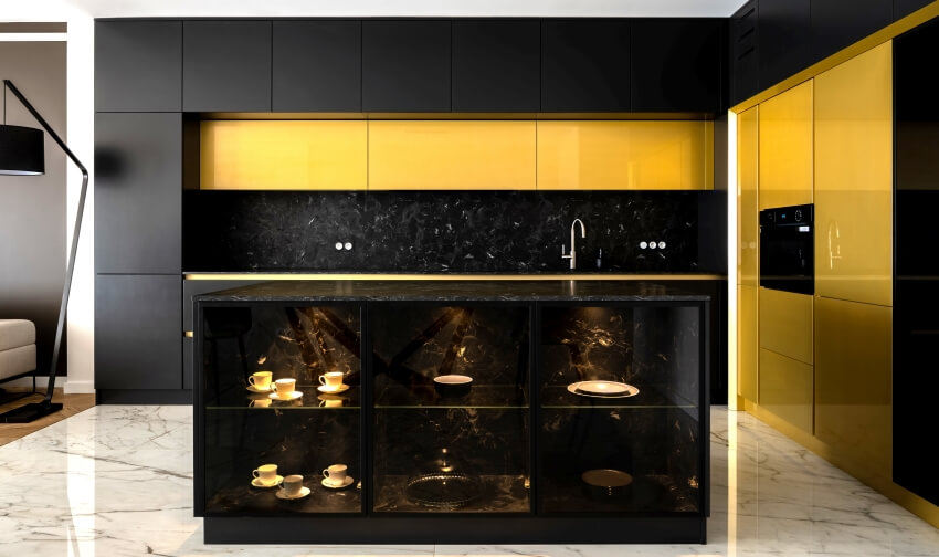 Gold and black kitchen with marble island with cubby storage, and marble floor tiles