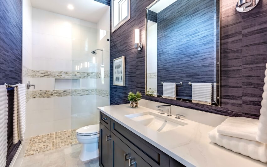 Gorgeous blue and white bathroom with quartzite countertop and mosaic tile floor shower