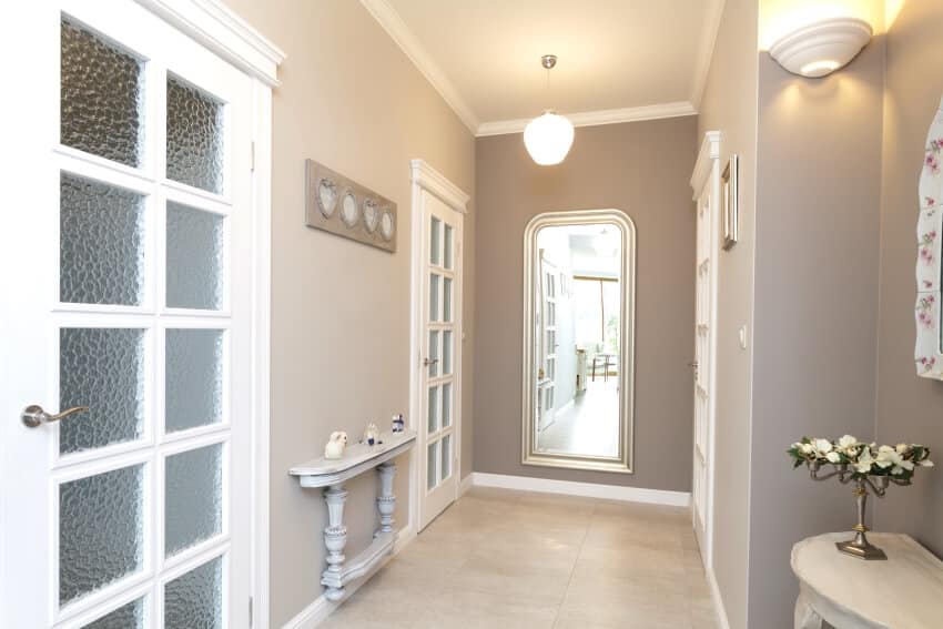 Grey hallway with huge mirror, wall mounted table, and pendant light