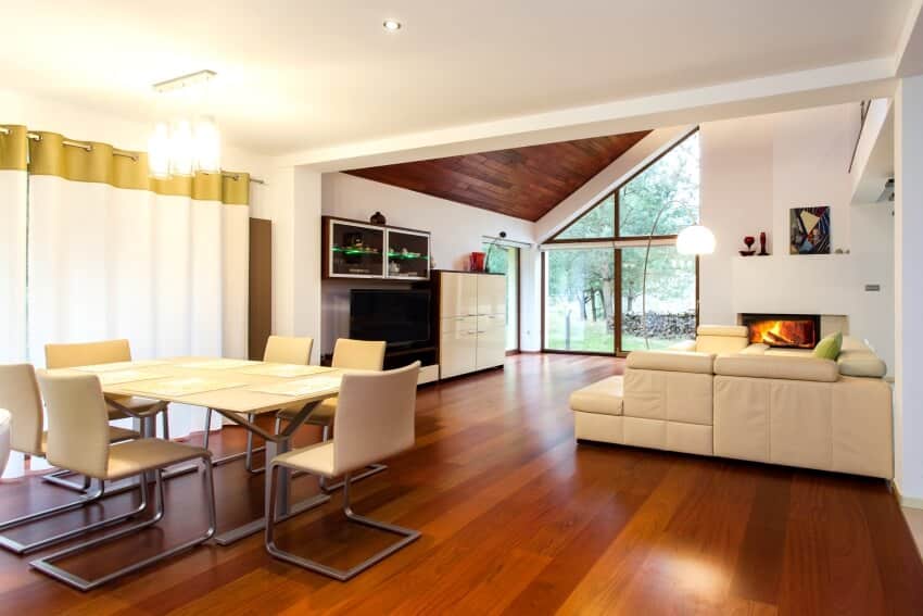 Ground floor of modern house with red oak wood floor, white furniture, and a fireplace