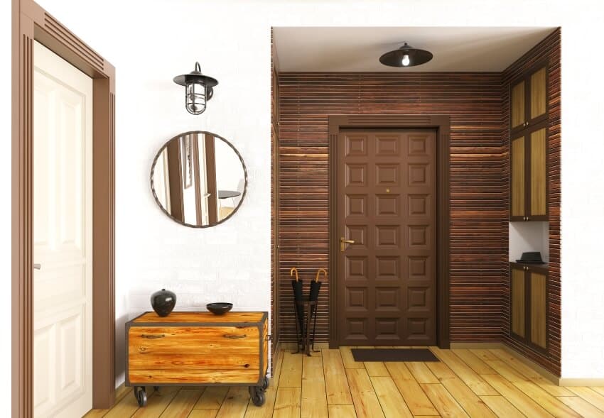 Brown panel wall, mirror, and sconce light and pine wood floor