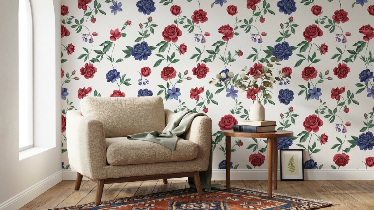 Bold red and blue hand screened floral wallpaper behind a cream armchair