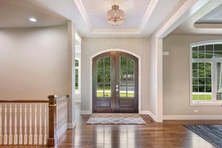 Hardwood flooring and rattan pendant light on detailed ceiling in an entrance hallway