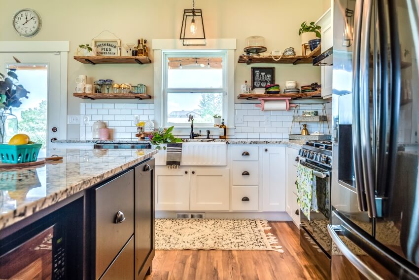 Hardwood flooring, floating shelves, beige walls, granite countertops, and apron sink in small kitchen