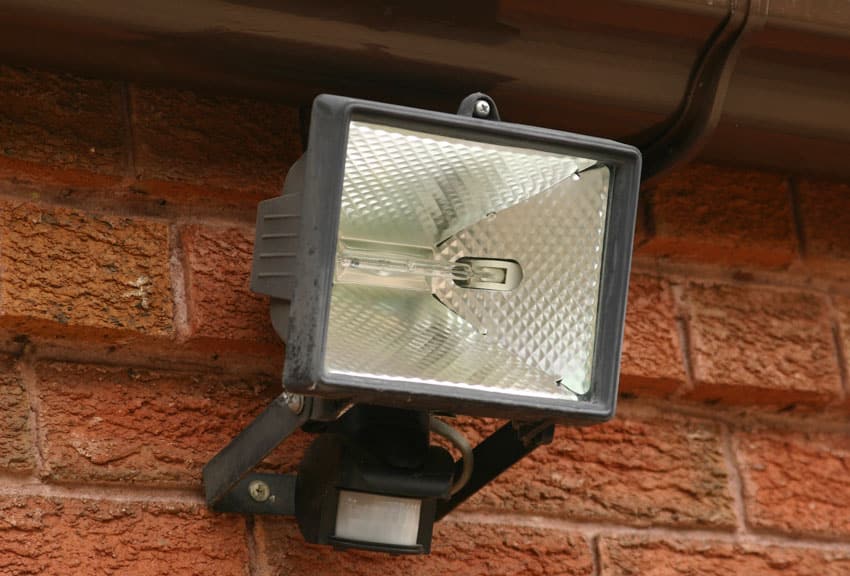 Heavy duty flood light with motion sensor installed on brick wall