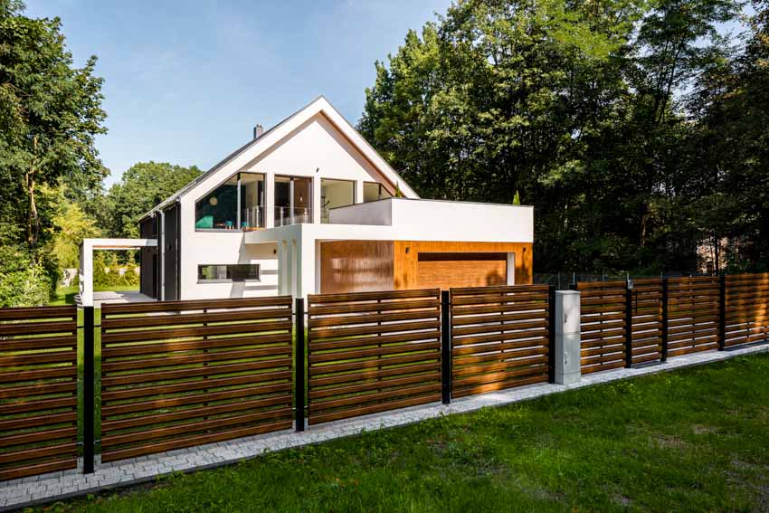 House design with brown Hardie board fence, pitched roof, and windows