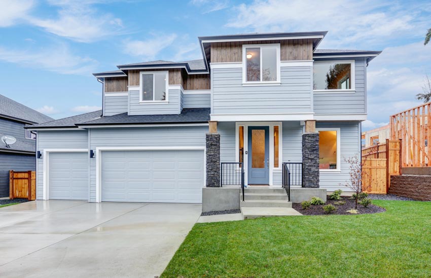 Exterior design with garage double door, polished driveway, and light blue siding