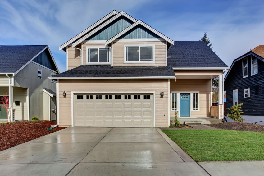 Exterior with garage, pavement driveway, windows, two tone paint