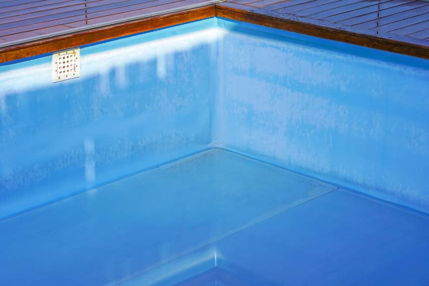 Image of empty pool with liner, and wood coping