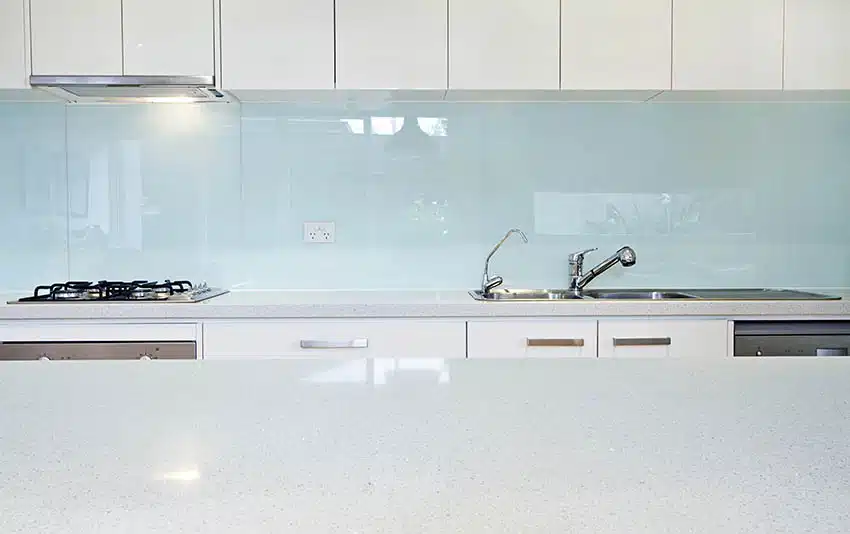 Kitchen with crushed glass countertops back painted blue glass backsplash