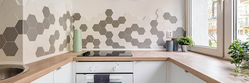 Kitchen with faux wood countertops geometric tile backsplash
