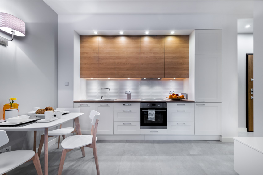 Kitchen with lighting fixtures, dining area, countertop, backsplash, shaker, and flat panel cabinets