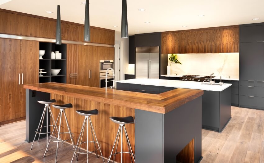 Large kitchen with wood cabinets, and two islands with white and quartz and wood bar surfaces