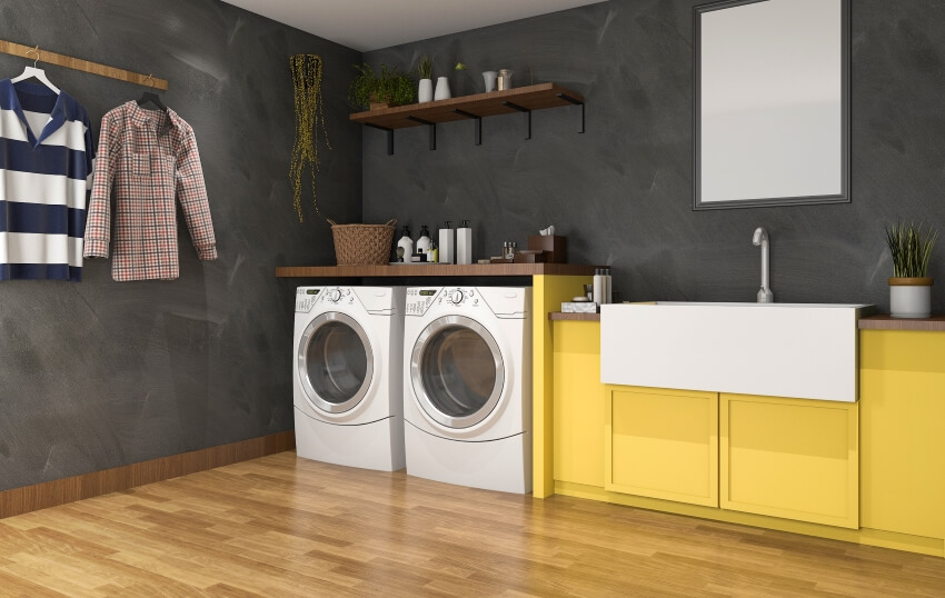 Laundry room with loft wall, wood floor, and narrow utility sink with yellow base cabinet