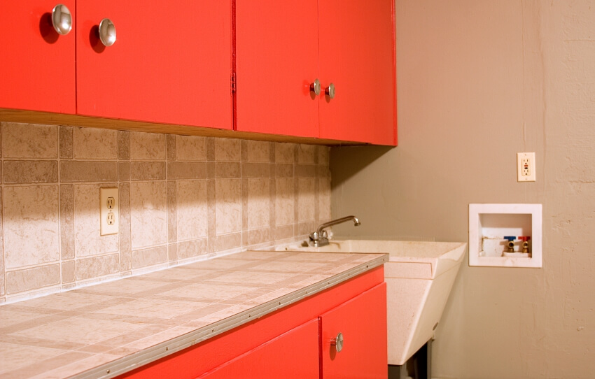Laundry room with orange cabinets and acrylic sink