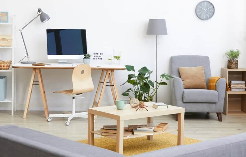 Living room with armchair, lamps, and office area with computer on wooden table