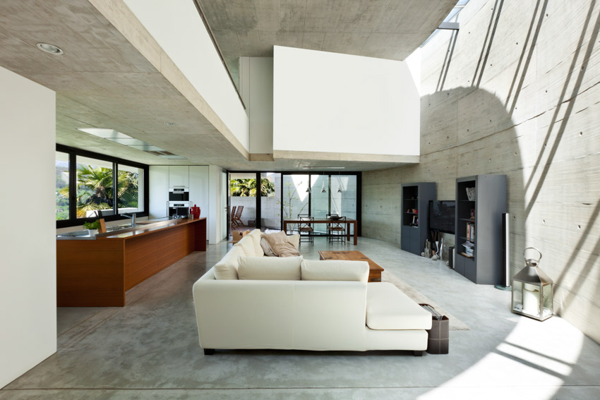 Living room with concrete overlay, couch, windows, and ceiling lights
