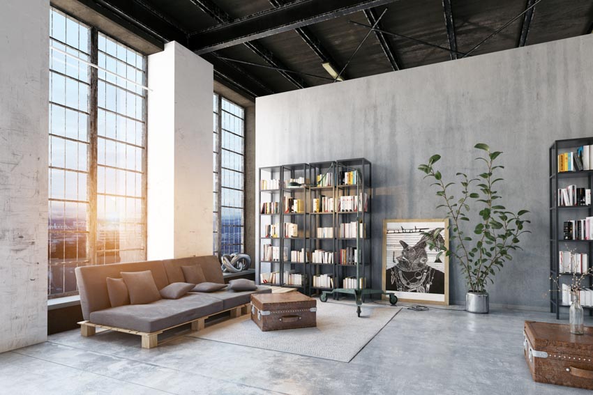 Living room with couch, windows, bookshelves, and concrete overlay
