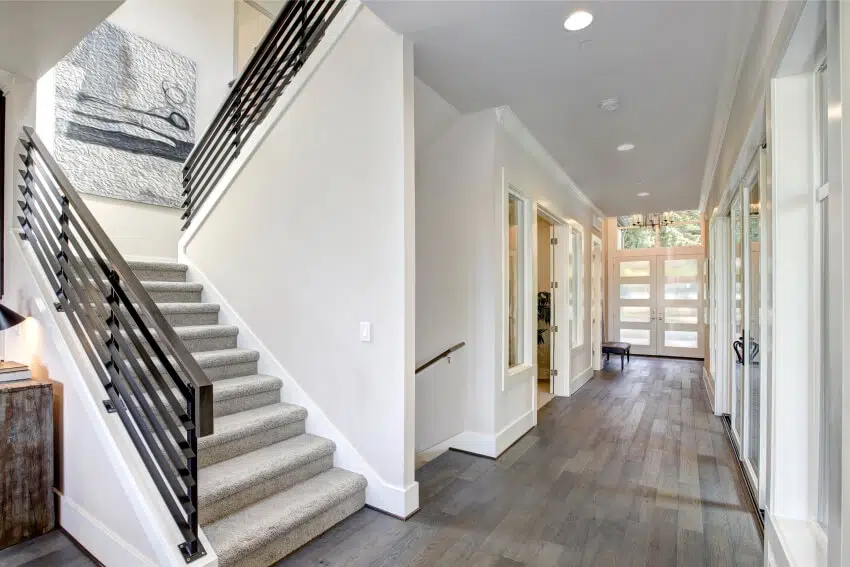 Long hallway with recessed lighting, staircase and hardwood floors