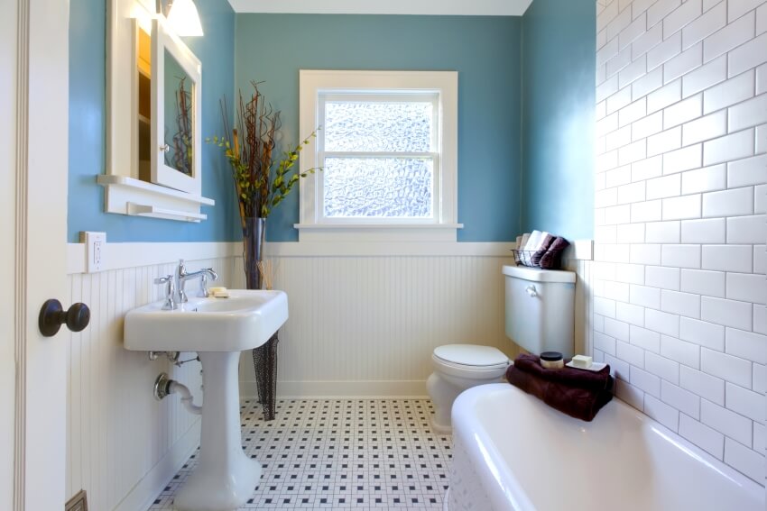 Luxurious antique blue bathroom with pedestal sink, subway tile wall, and mosaic tile floor
