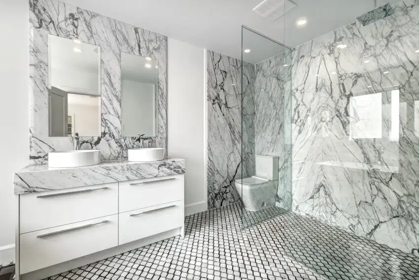 Luxurious bathroom with glass enclosed shower and two wash basins on marble countertop
