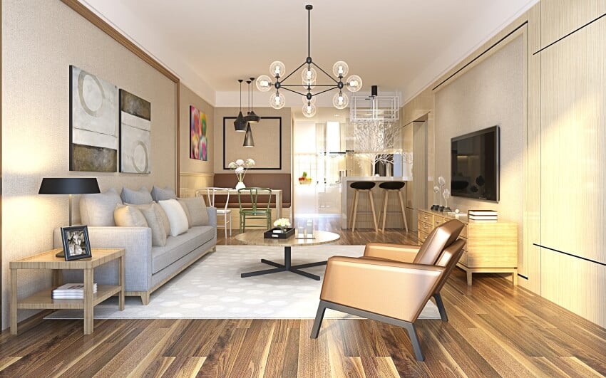 Luxury house interior with cream colored walls, pendant lights, and wood floors and furniture
