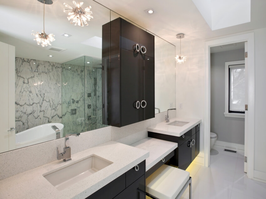 Master bathroom with double sink vanity, pendant lights, and marble wall