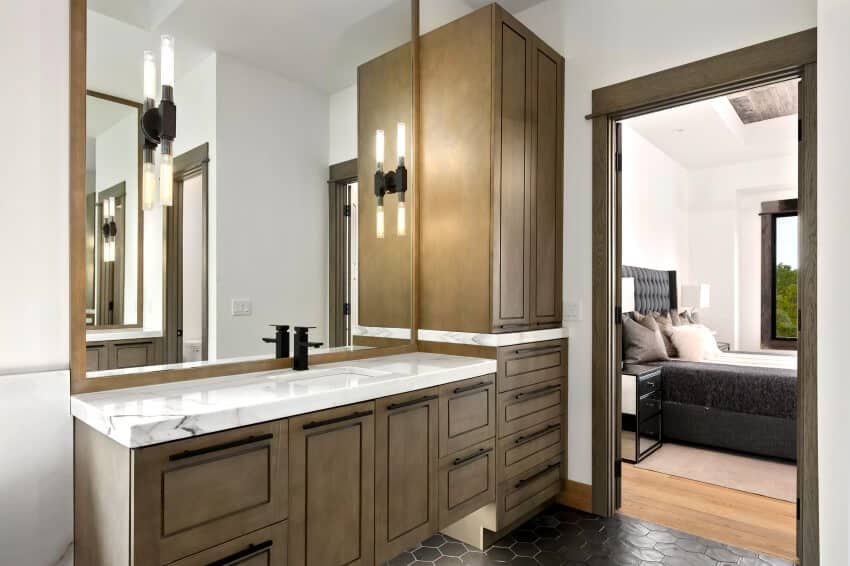 Master bathroom with honeycomb vinyl floor, and wooden vanity cabinets with marble countertop