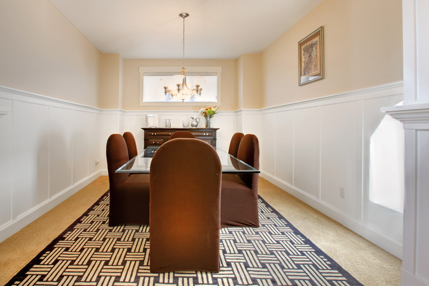 Room with white molding, wainscoting and brown carpet