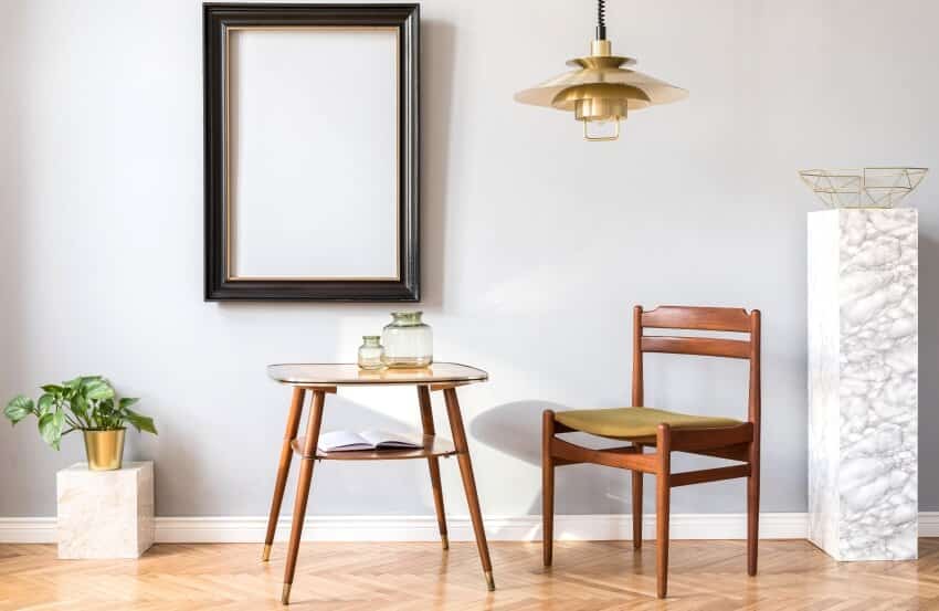 Minimalist living room with design chair, gold pendant light, coffee table, and marble stands